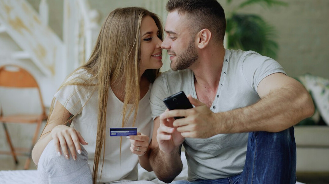 Danish couple reviewing household finances together at kitchen table