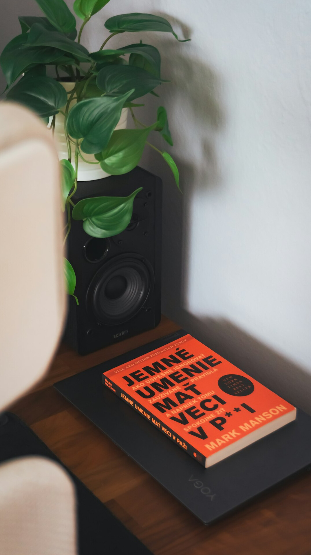 Stack of books and a notebook with a pen on a wooden desk