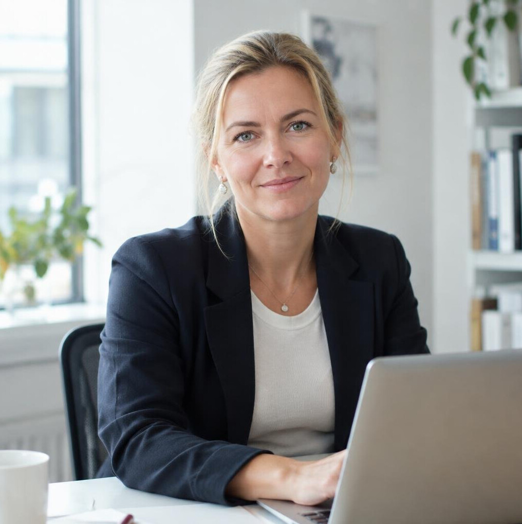 Danish female editor working at a desk with a laptop